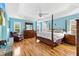 Spacious main bedroom featuring wood floors, tray ceiling and lots of natural light at 3233 Belcherry Loop, The Villages, FL 32163