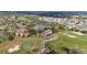 Aerial view of a golf course community featuring a clubhouse, golf carts, and tennis courts at 3234 Berkeley Ln, The Villages, FL 32162