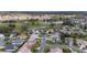 An aerial view of a residential community with a golf course and pond, showcasing well-maintained homes and landscapes at 3234 Berkeley Ln, The Villages, FL 32162