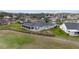 An aerial view of a home with a spacious screened-in lanai, situated on a well-maintained lot next to a golf course at 3234 Berkeley Ln, The Villages, FL 32162