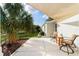Relaxing back patio with a sun shade, tropical landscaping, and comfortable patio furniture at 3234 Berkeley Ln, The Villages, FL 32162