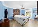 Cozy bedroom featuring blue walls, a decorative quilt, a window, and neutral tile floors at 3234 Berkeley Ln, The Villages, FL 32162