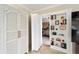View from the living area into bedroom through doorway flanked by built-in bookshelves and a linen closet at 3234 Berkeley Ln, The Villages, FL 32162
