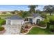 Charming home with a well-manicured lawn, beautiful landscaping, and a paved driveway leading to a two-car garage at 3234 Berkeley Ln, The Villages, FL 32162