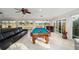 Bright game room with a billiard table, comfortable seating, and large windows overlooking the outdoors at 3234 Berkeley Ln, The Villages, FL 32162