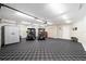 Spacious garage with checkered floor tiles, storage cabinets, and two golf carts parked inside at 3234 Berkeley Ln, The Villages, FL 32162