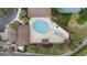Aerial view of the community pool shaped like a tennis racket with lounge chairs at 3234 Berkeley Ln, The Villages, FL 32162