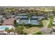Aerial view of community tennis courts, pool and clubhouse surrounded by lush landscaping at 3234 Berkeley Ln, The Villages, FL 32162