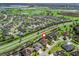 Community aerial view of a residential neighborhood with a golf course, and plentiful trees at 3654 Enterprise Dr, The Villages, FL 32163