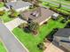 Aerial shot of a home with manicured lawn and landscaping, including palm trees and a screened in porch at 3654 Enterprise Dr, The Villages, FL 32163