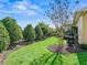 Beautiful backyard with lush greenery, manicured shrubs, mulch beds, and a charming decorative fountain at 3654 Enterprise Dr, The Villages, FL 32163
