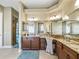 Bathroom featuring double sinks, vanity, mirrors, cabinets, tile floor, and a walk-in shower at 3654 Enterprise Dr, The Villages, FL 32163