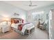 Cozy bedroom with a ceiling fan, shuttered windows, and a comfortable sitting area at 3654 Enterprise Dr, The Villages, FL 32163