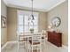 Cozy dining area with white table, white chairs, shuttered window, and accent cabinet at 3654 Enterprise Dr, The Villages, FL 32163