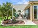 Well maintained exterior showcasing a covered patio with outdoor seating and a grill, surrounded by mature trees at 3654 Enterprise Dr, The Villages, FL 32163