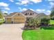 Charming home featuring a three-car garage, lush landscaping, and a well-manicured lawn at 3654 Enterprise Dr, The Villages, FL 32163