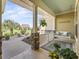 Relaxing front porch features a swing, stylish decor, and views of lush landscaping and mature palm trees at 3654 Enterprise Dr, The Villages, FL 32163