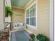 Inviting front porch with a swing, ferns, and stone accents, perfect for relaxing outdoors at 3654 Enterprise Dr, The Villages, FL 32163