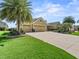 Beautiful home with a three-car garage and professional landscaping, including mature palm trees at 3654 Enterprise Dr, The Villages, FL 32163