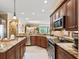 Spacious kitchen featuring granite countertops, stainless steel appliances, and wooden cabinetry at 3654 Enterprise Dr, The Villages, FL 32163