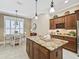 Bright kitchen featuring a large island with granite countertop and pendant lighting at 3654 Enterprise Dr, The Villages, FL 32163