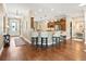 Open-concept kitchen featuring a breakfast bar with white stools and hardwood floors at 3654 Enterprise Dr, The Villages, FL 32163