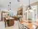 Open-concept kitchen with wooden island, stainless steel appliances, and adjacent dining area with elegant chandelier at 3654 Enterprise Dr, The Villages, FL 32163