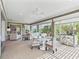 Bright living room with multiple seating areas, dining table, and a wall of windows at 3654 Enterprise Dr, The Villages, FL 32163