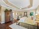 Bright main bedroom has tray ceilings, hardwood floors, and ensuite bathroom at 3654 Enterprise Dr, The Villages, FL 32163