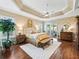 Spacious main bedroom featuring hardwood floors and a decorative tray ceiling with fan at 3654 Enterprise Dr, The Villages, FL 32163