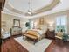 Spacious main bedroom with tray ceilings, hardwood floors and bright, natural light at 3654 Enterprise Dr, The Villages, FL 32163