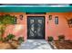 Elegant front entrance with custom doors and wall sconces, accented by neat landscaping for a welcoming feel at 36816 Taylor Mill Rd, Fruitland Park, FL 34731