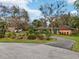 Charming one-story home featuring colorful accents, a circular driveway and lush landscaping at 36816 Taylor Mill Rd, Fruitland Park, FL 34731