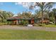 Well-manicured front yard showcasing a charming home with a unique paint job and mature landscaping at 36816 Taylor Mill Rd, Fruitland Park, FL 34731