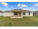 Spacious backyard featuring a covered patio, lush green lawn, and a neutral colored home at 4000 Se 98Th Pl, Belleview, FL 34420