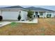 Inviting front exterior featuring a two-car garage, blue front door, and manicured landscaping at 4000 Se 98Th Pl, Belleview, FL 34420