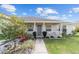 Charming home exterior featuring a cozy covered front porch and lush, landscaped garden at 4000 Se 98Th Pl, Belleview, FL 34420