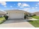 Home exterior showcasing a two-car garage with a driveway and meticulously maintained landscaping at 4000 Se 98Th Pl, Belleview, FL 34420