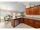 Well-lit kitchen featuring wooden cabinets, granite countertops, stainless steel appliances, and an adjacent dining area at 4000 Se 98Th Pl, Belleview, FL 34420