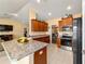 Open kitchen with granite counters, stainless appliances, and view into living area at 4000 Se 98Th Pl, Belleview, FL 34420