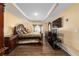Well-lit main bedroom featuring hardwood flooring, dark wood furniture, a tray ceiling, and ample natural light at 4000 Se 98Th Pl, Belleview, FL 34420