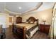 Main bedroom featuring a tray ceiling, dark wood furniture, and hardwood flooring at 4000 Se 98Th Pl, Belleview, FL 34420