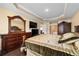 Cozy main bedroom showcasing a tray ceiling, dark wood furniture, and hardwood flooring at 4000 Se 98Th Pl, Belleview, FL 34420