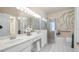 Well-lit bathroom with double sinks, tile floor and a walk-in shower at 4110 Hammersmith Dr, Clermont, FL 34711