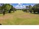 Scenic golf course with a long green fairway, mature trees, and beautiful sunny skies at 4110 Hammersmith Dr, Clermont, FL 34711