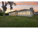 Expansive backyard featuring a sunroom with large windows, perfect for enjoying the outdoors from inside at 5135 Aurora Dr, Leesburg, FL 34748