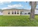 The house is a single-story home with a well-maintained lawn and mature trees at 5135 Aurora Dr, Leesburg, FL 34748