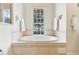 Bathroom featuring an expansive garden tub set against a large window, with decoratively tiled trim at 5135 Aurora Dr, Leesburg, FL 34748