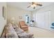 Cozy bedroom with a ceiling fan, closet, and comfortable seating area with natural light at 5135 Aurora Dr, Leesburg, FL 34748