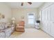 Bright bedroom featuring neutral walls, a ceiling fan, and a comfy seating area with a double-door closet at 5135 Aurora Dr, Leesburg, FL 34748